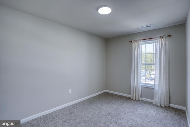 unfurnished room with carpet floors, baseboards, and visible vents