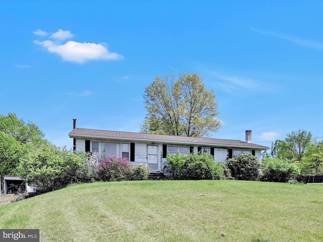 single story home with a chimney and a front lawn
