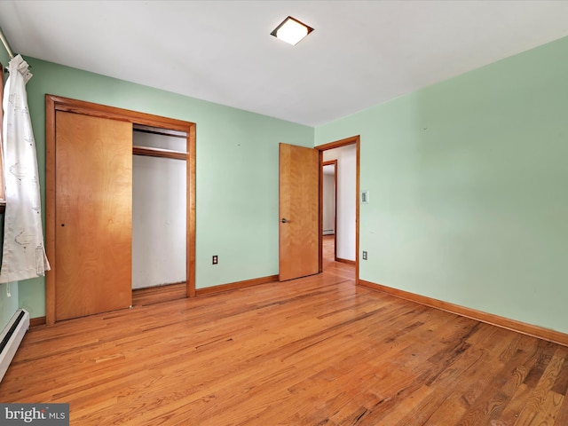 unfurnished bedroom with a closet, baseboards, and light wood-style floors