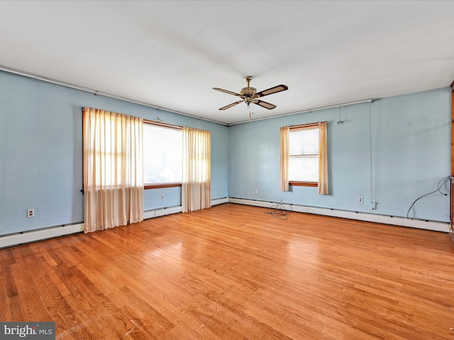 spare room featuring ceiling fan, wood finished floors, and a wealth of natural light