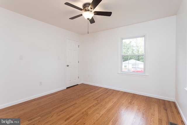 unfurnished room with baseboards, a ceiling fan, and light wood-style flooring