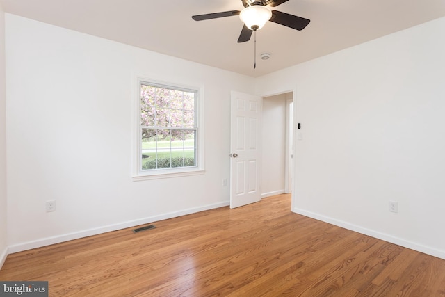 unfurnished room featuring visible vents, a ceiling fan, light wood finished floors, and baseboards