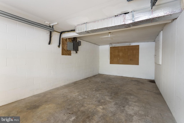 basement featuring concrete block wall and a garage