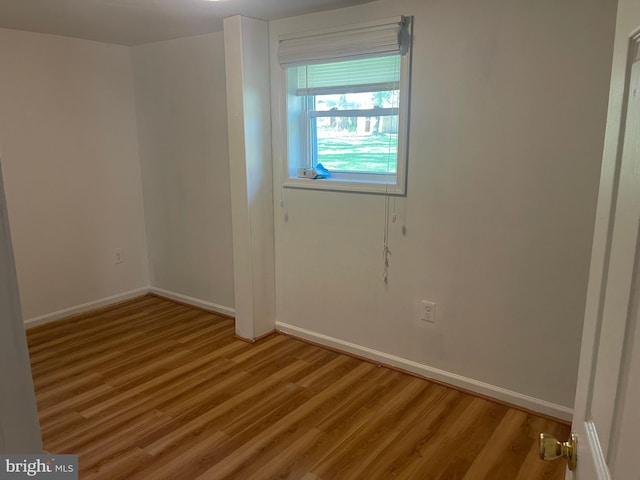 empty room with baseboards and light wood-style flooring