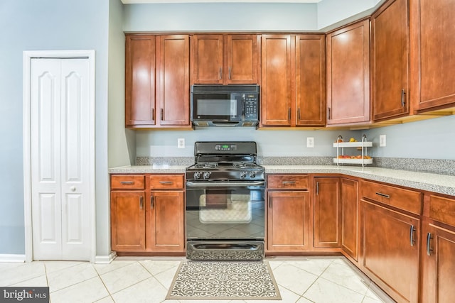 kitchen featuring light tile patterned floors, black appliances, and light stone countertops
