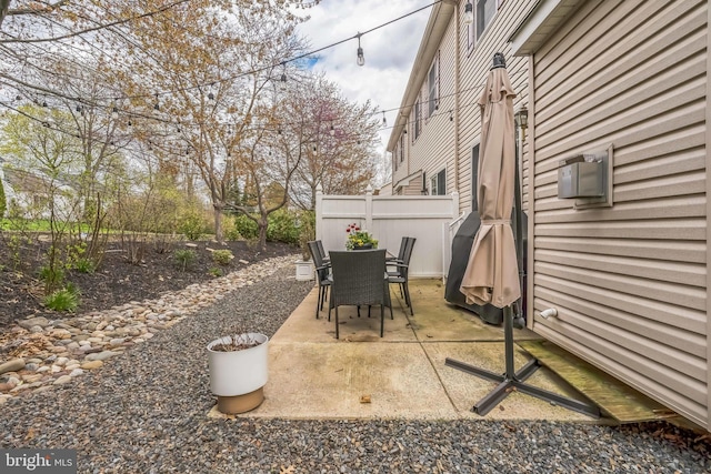 view of patio with outdoor dining area and fence