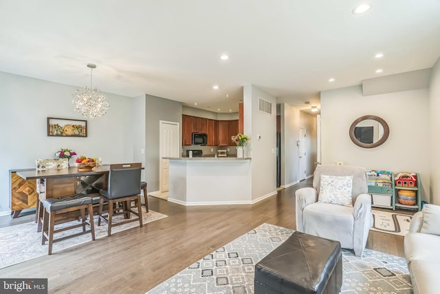 living area with visible vents, light wood-type flooring, and baseboards