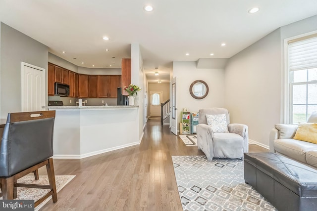 living area with stairway, light wood-type flooring, recessed lighting, and baseboards