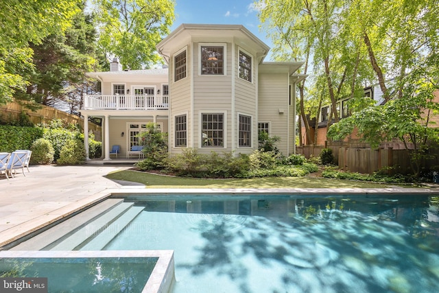 back of house with a patio, fence, a chimney, and a pool with connected hot tub