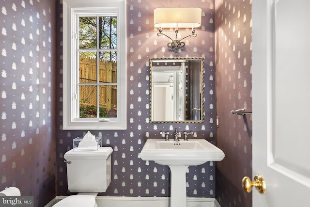 half bath featuring toilet and wallpapered walls