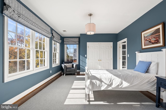 carpeted bedroom featuring a closet, visible vents, and baseboards