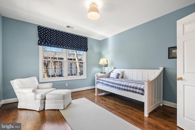 bedroom featuring wood finished floors, visible vents, and baseboards