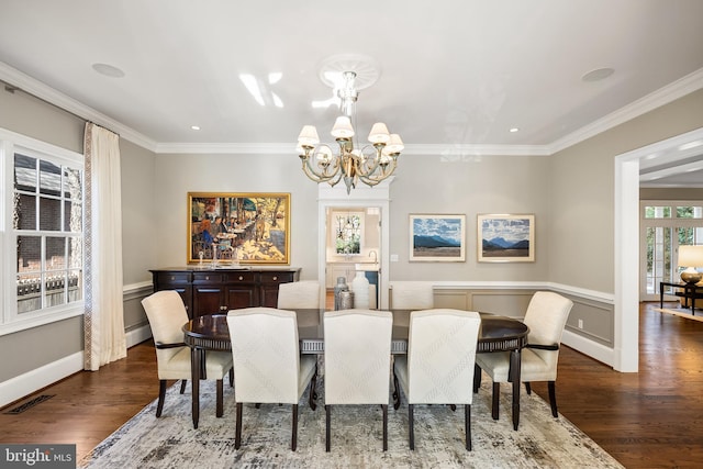 dining space featuring dark wood finished floors, visible vents, a notable chandelier, and crown molding