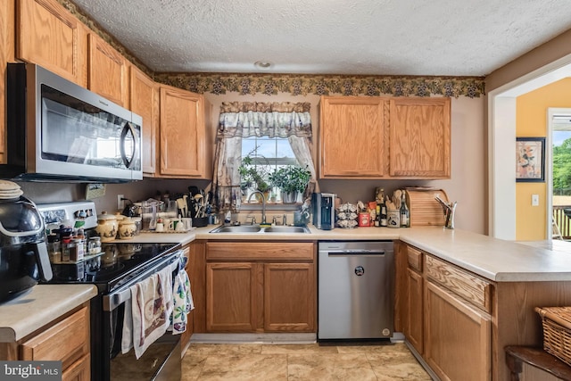 5135 Clark Canning House Rd, Federalsburg, MD 21632 - kitchen featuring stainless steel appliances, a sink, a peninsula, light countertops, and a textured ceiling