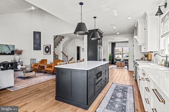 kitchen featuring light wood-style flooring, light countertops, white cabinets, and recessed lighting