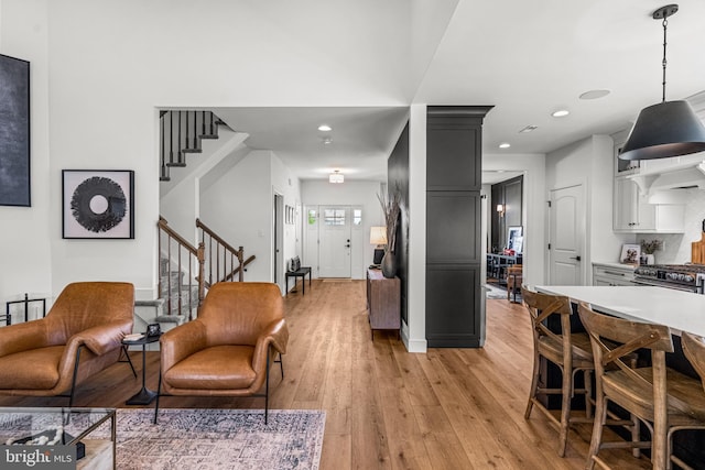 living room with recessed lighting, stairs, and light wood finished floors