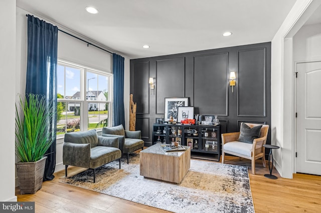 sitting room featuring recessed lighting, light wood-style floors, and a decorative wall