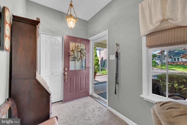 entryway with baseboards, a wealth of natural light, and light colored carpet