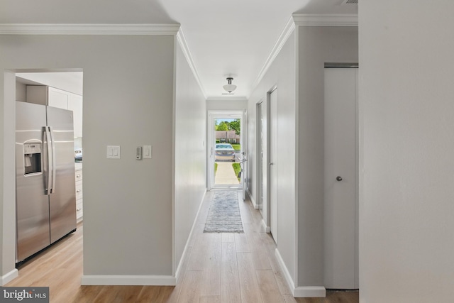 corridor with crown molding, baseboards, and light wood-style floors