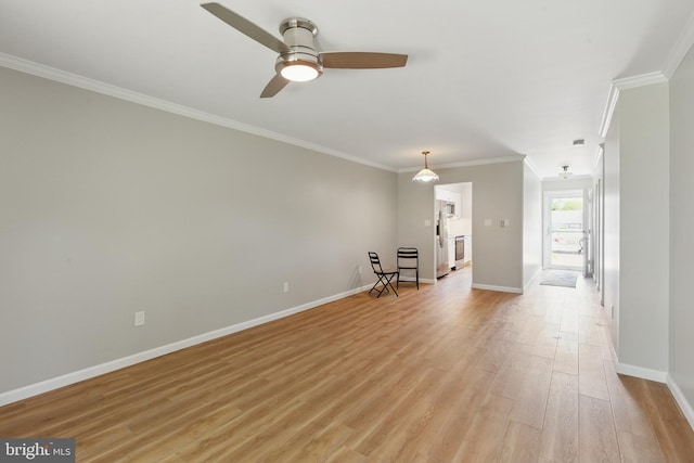 interior space featuring light wood-type flooring, baseboards, crown molding, and ceiling fan