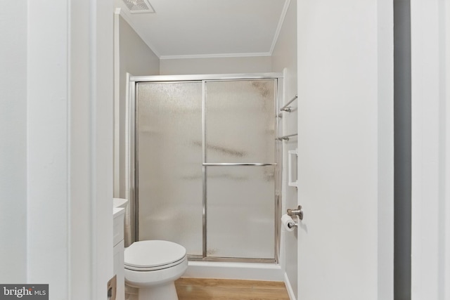 full bathroom featuring ornamental molding, a stall shower, wood finished floors, and visible vents