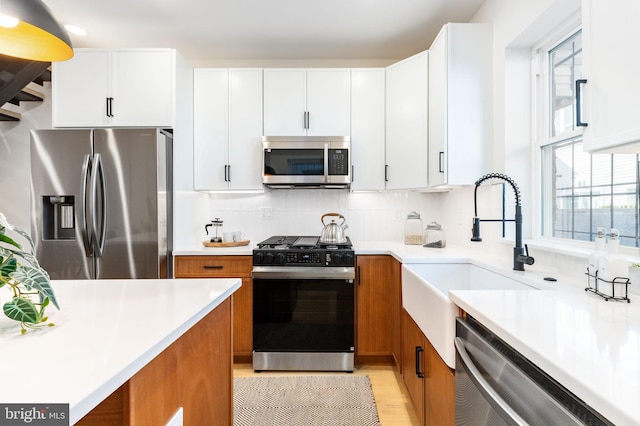 2131 Wharton St, Philadelphia, PA 19146 - kitchen with brown cabinetry, tasteful backsplash, light countertops, white cabinets, and stainless steel appliances