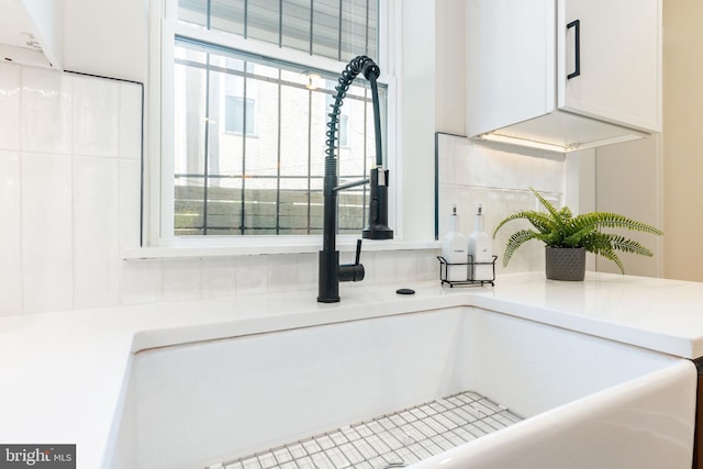2131 Wharton St, Philadelphia, PA 19146 - details featuring a sink, light countertops, backsplash, and white cabinetry