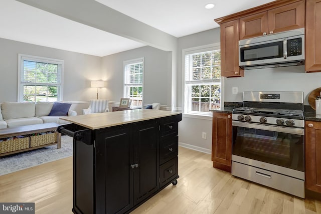 6825 Kincaid Ave, Falls Church, VA 22042 - kitchen featuring appliances with stainless steel finishes, baseboards, open floor plan, dark cabinets, and light wood-style flooring