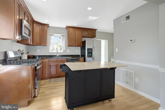 6825 Kincaid Ave, Falls Church, VA 22042 - kitchen with stainless steel appliances, visible vents, a sink, and light wood-type flooring