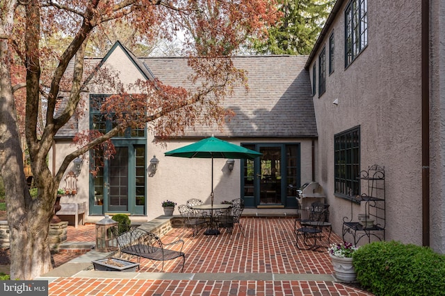 back of property featuring outdoor dining space, a patio area, and stucco siding