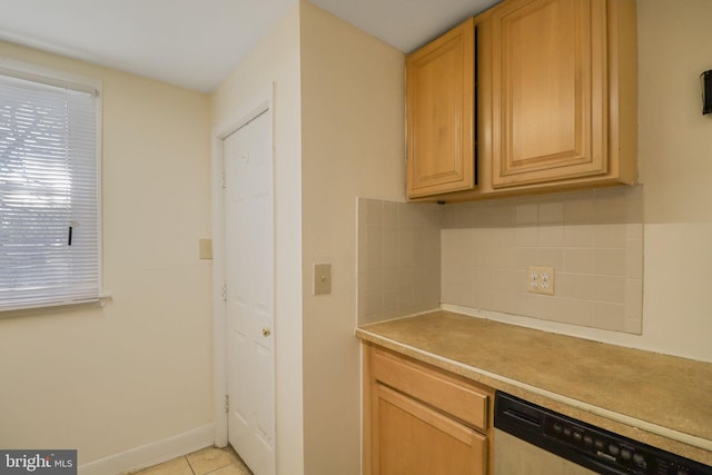 kitchen featuring light tile patterned flooring, light countertops, baseboards, tasteful backsplash, and dishwashing machine