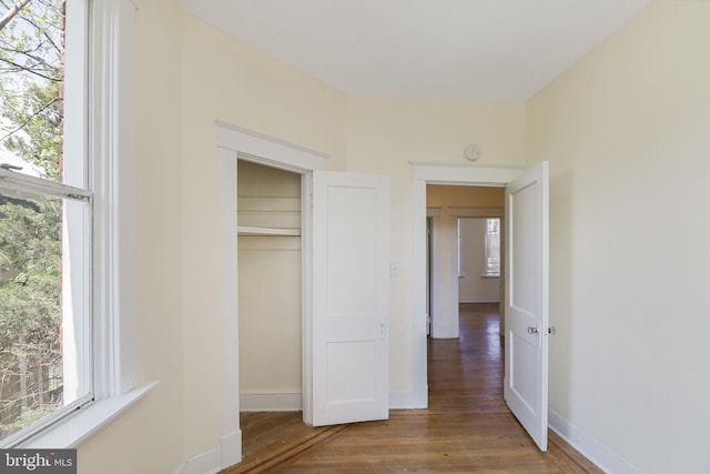 unfurnished bedroom featuring baseboards, a closet, and wood finished floors