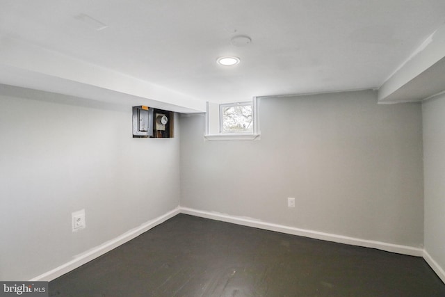 basement with baseboards and wood finished floors