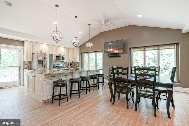 11 Lippincott Ave, Voorhees, NJ 08043 - dining area with light wood-type flooring, ceiling fan with notable chandelier, vaulted ceiling, and a healthy amount of sunlight