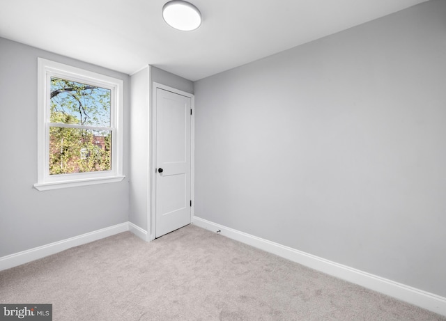 carpeted spare room featuring baseboards