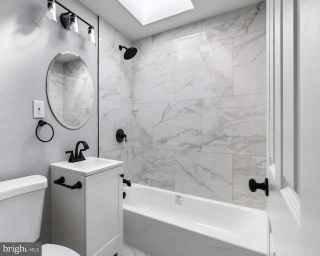 bathroom with washtub / shower combination, vanity, toilet, marble finish floor, and a skylight
