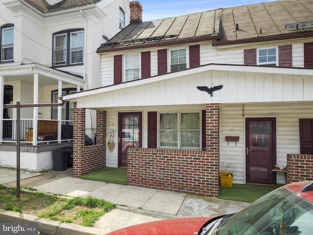 view of front of property featuring covered porch and brick siding