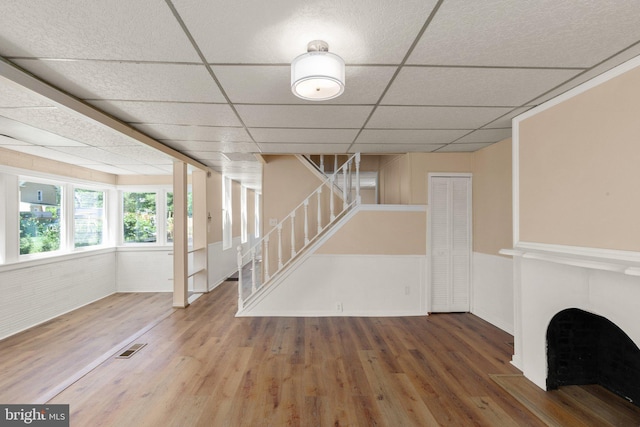 916 N Kresson St, Baltimore, MD 21205 - unfurnished living room with visible vents, stairway, wood finished floors, and a drop ceiling