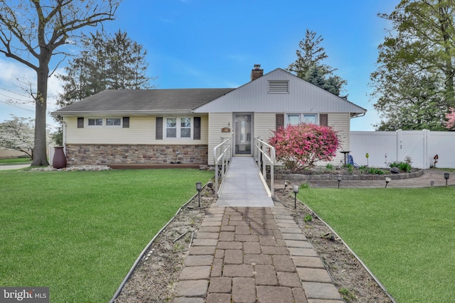 view of front facade with fence, a front yard, and a chimney