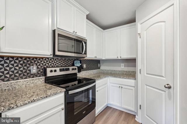 17026 Rollins Rd, Bowling Green, VA 22427 - kitchen with light wood-style flooring, stainless steel appliances, white cabinetry, decorative backsplash, and light stone counters