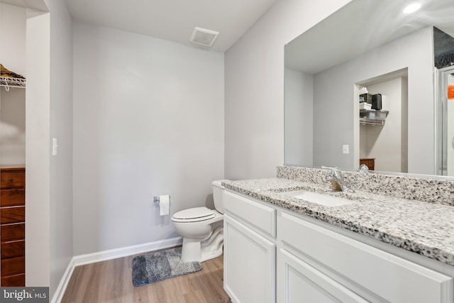 17026 Rollins Rd, Bowling Green, VA 22427 - bathroom with toilet, wood finished floors, vanity, visible vents, and baseboards