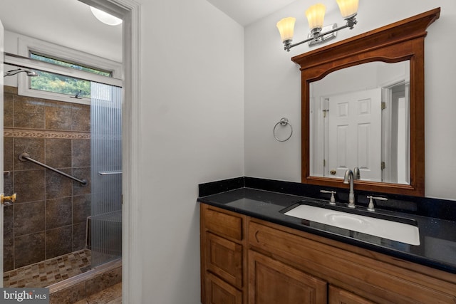 full bath with tiled shower and vanity