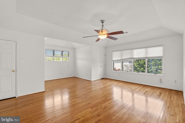 empty room with vaulted ceiling, baseboards, a ceiling fan, and light wood-type flooring