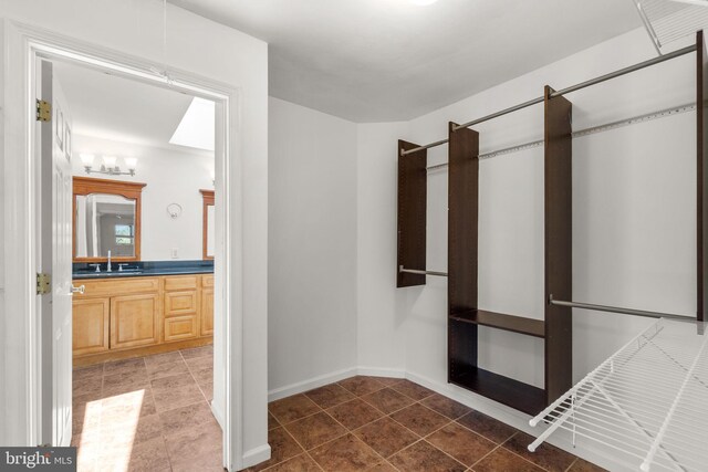 spacious closet with a sink and tile patterned floors