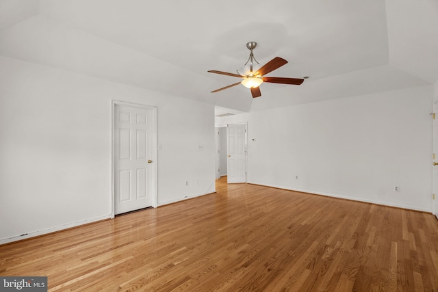 spare room featuring a ceiling fan, baseboards, and light wood finished floors