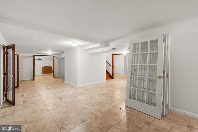 unfurnished room with baseboards, light tile patterned flooring, visible vents, and stairway