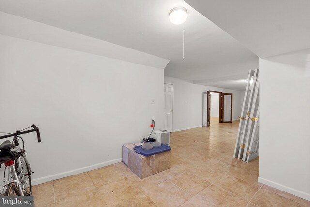 interior space with baseboards and light tile patterned flooring