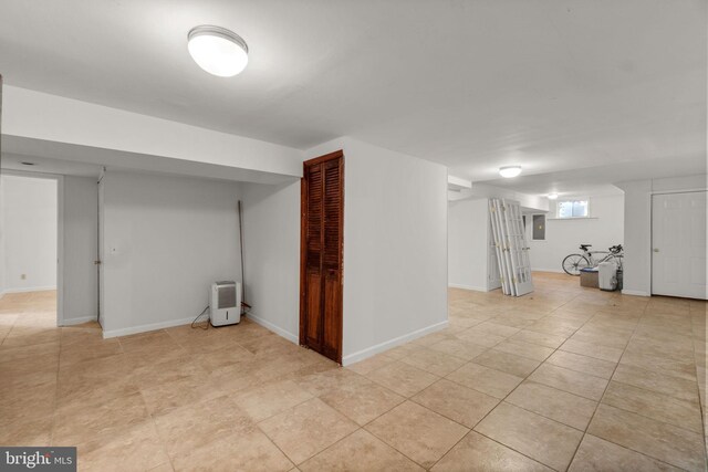 basement featuring baseboards and light tile patterned floors