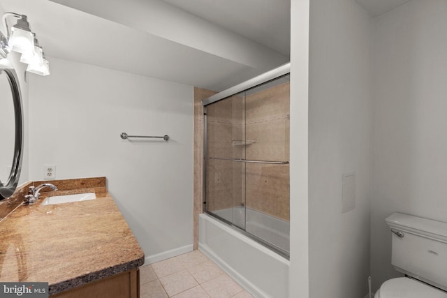 bathroom featuring tile patterned flooring, vanity, toilet, baseboards, and combined bath / shower with glass door