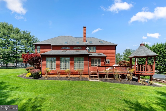back of property featuring a gazebo, a yard, a deck, and a chimney